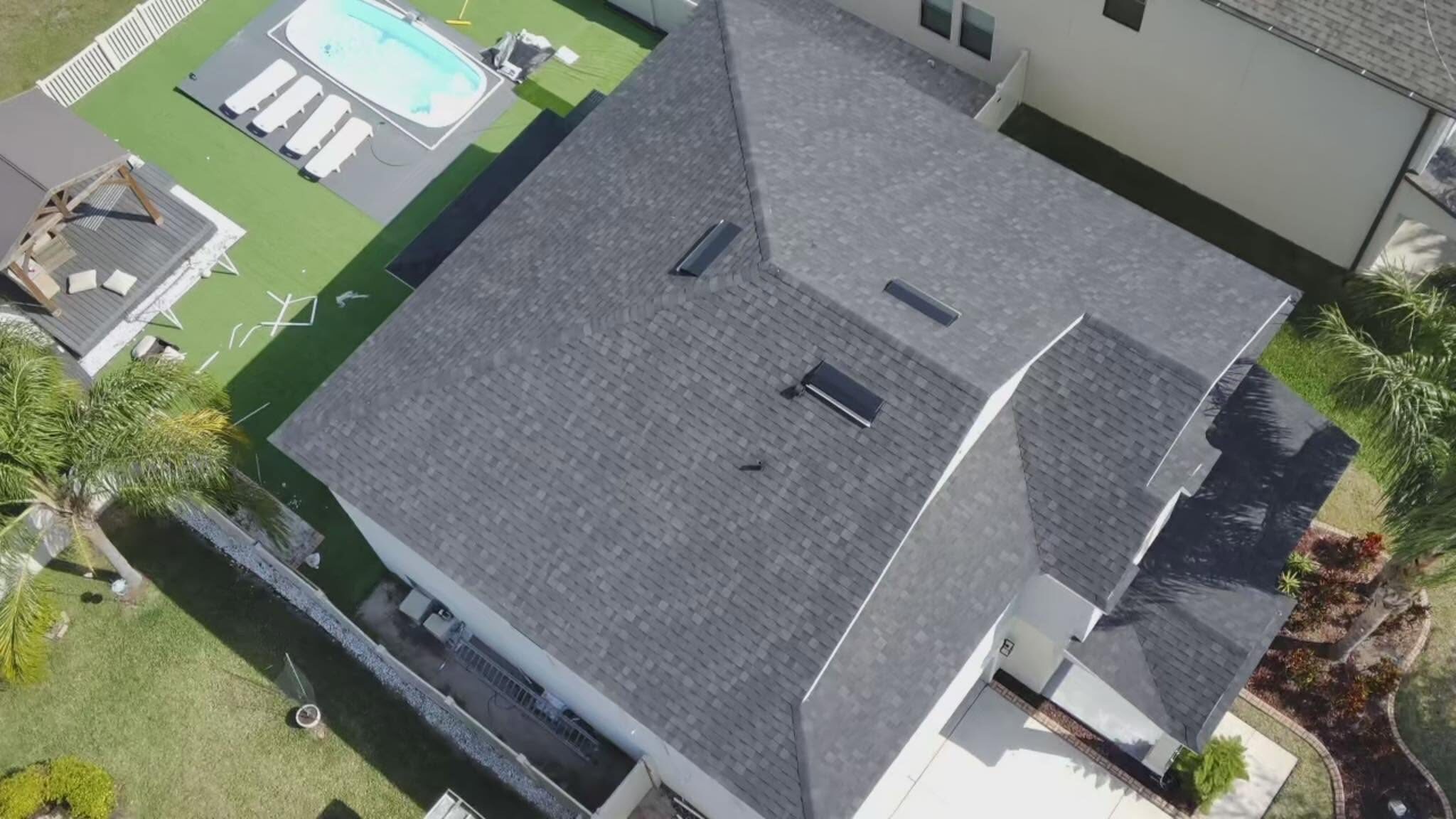 Aerial view of finished dimensional shingle roof over a home with pool and gazebo