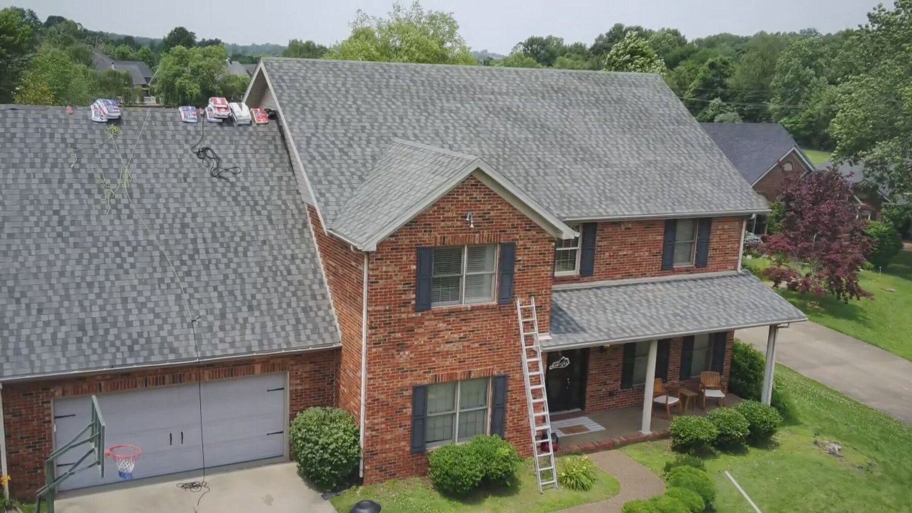 Aerial view of a complete dimensional shingle re-roof on a brick two-story home